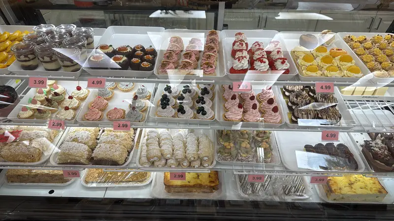 Pastry case with tartlets, eclairs and cream rolls